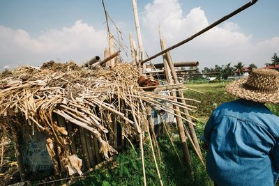 Rear view of person standing by hut on farm