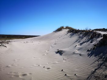 Scenic view of desert against clear blue sky