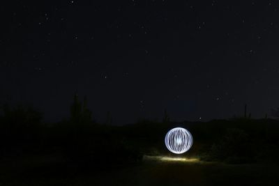 Illuminated landscape against sky at night