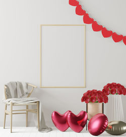 Red flowers on table against wall at home