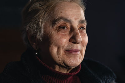 Close-up portrait of young man against black background
