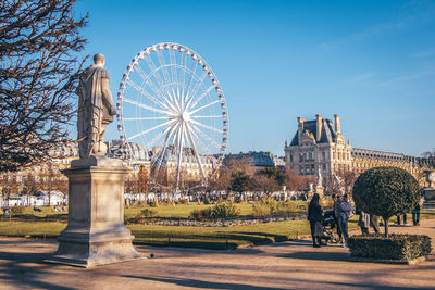 Statue of ferris wheel against blue sky