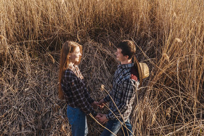 Man and woman standing by plants