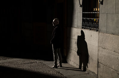 Adult man in suit on street in winter with sunlight and shadow