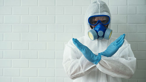 Portrait of man standing against white wall