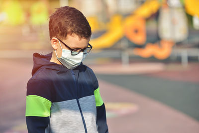 Close-up of boy wearing mask standing outdoors