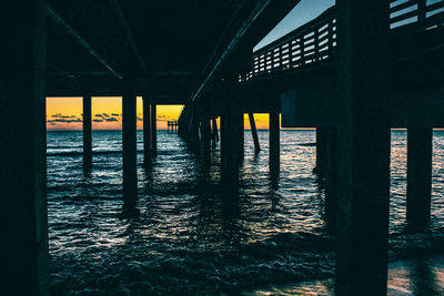 View of pier in sea during sunset
