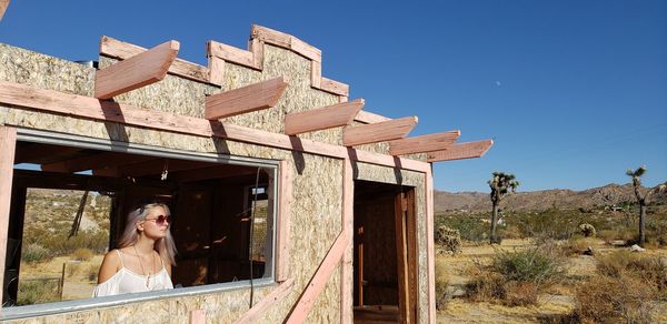 Woman looking at built structure against sky