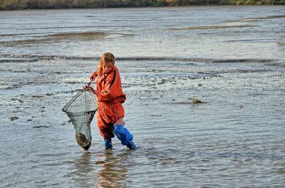 Woman holding fishing net at beach