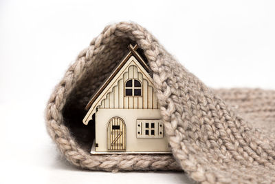 Close-up of model home and doormat against white background