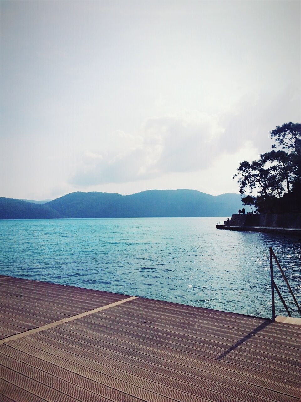 mountain, water, tranquil scene, sky, mountain range, scenics, tranquility, beauty in nature, lake, sea, nature, idyllic, pier, rippled, cloud - sky, railing, outdoors, day, no people, river