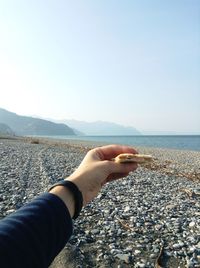 Low section of woman on beach against clear sky