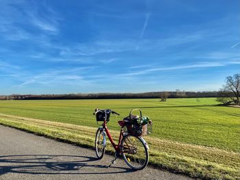 Bicycles parked on field against sky