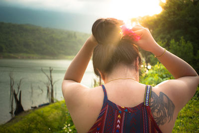 Rear view of women standing by tree against sky