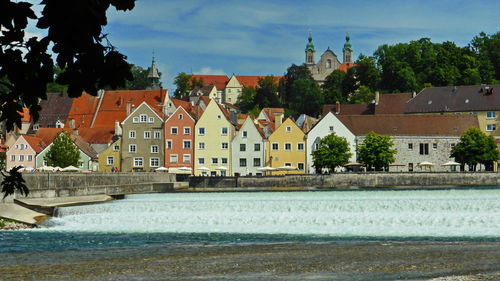 Buildings by swimming pool in town against sky