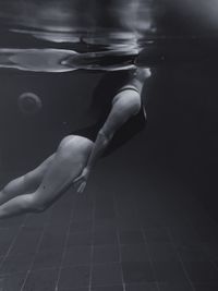 Low section of woman swimming in water