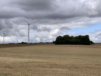 Scenic view of field against cloudy sky
