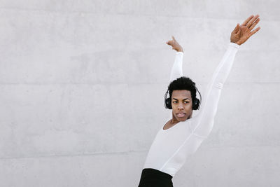 Portrait of young man standing against wall