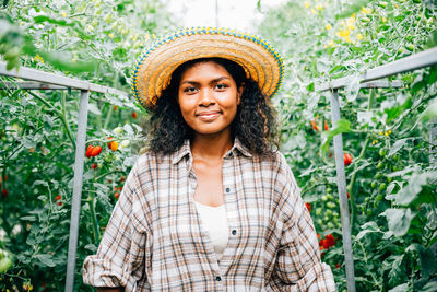 Young woman standing against plants