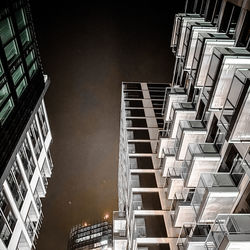 Low angle view of modern buildings against sky at night