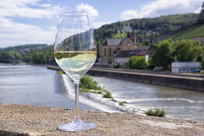 Close-up of wine glass on table against river