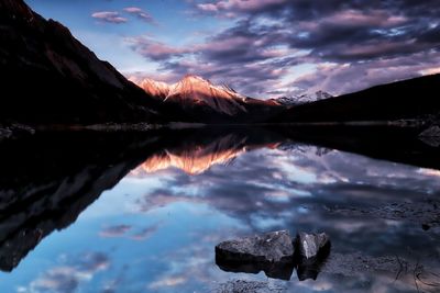 Scenic view of lake and mountains against sky during sunset