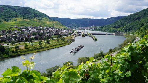 Scenic view of river with floodgate by moselle valley against sky