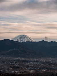 Scenic view of snowcapped mountain against cloudy sky