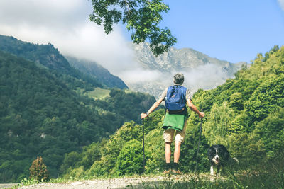 Man walking in mountain forest. male with backpack do hike in the nature. guy goes trekking outdoor