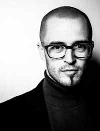 Portrait of young man wearing eyeglasses against white background