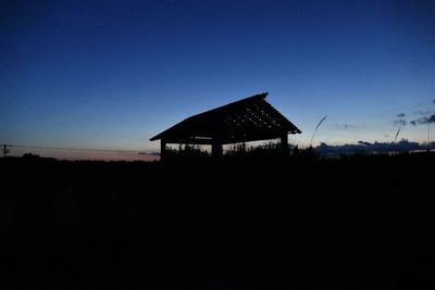 Silhouette built structure against clear blue sky