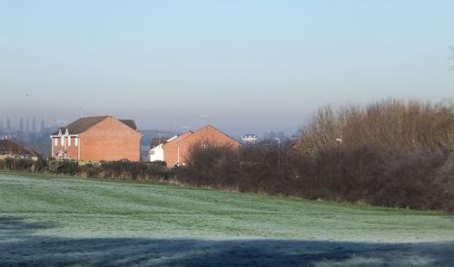 Houses on field against clear sky