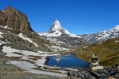 Scenic view of snowcapped mountains against clear blue sky