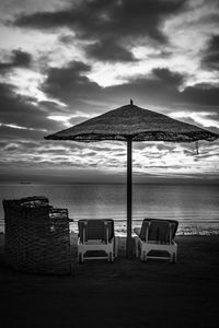 Chairs on beach against sky