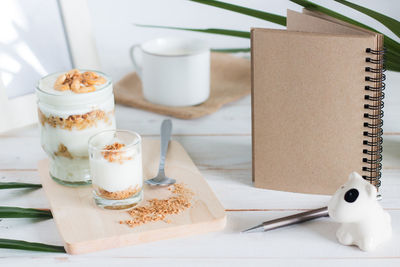 High angle view of dessert in glass by book and pen on table