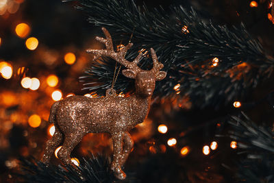 Retro christmas golden toy figurine of a deer hanging on a christmas tree. magic winter details 