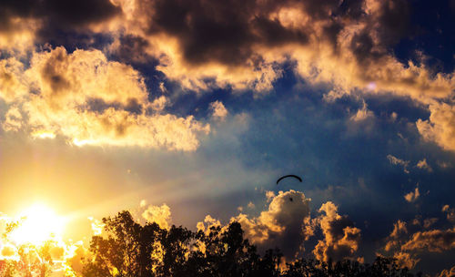 Low angle view of sun shining through clouds