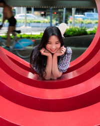Portrait of a smiling girl sitting in red dress