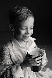 Close-up of smiling boy holding drink