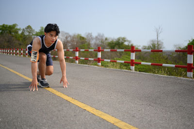 Full length of woman exercising on road