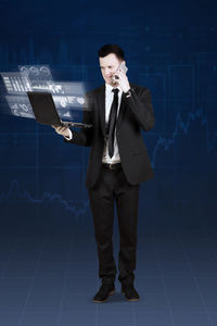 Digital composite image of businessman using laptop with icons