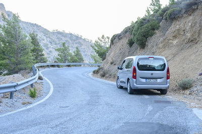 Car on road by mountain against sky