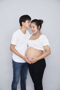 Young couple standing against white background