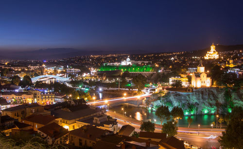 High angle view of city lit up at night