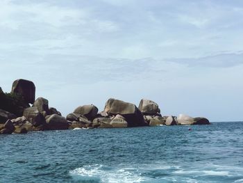 Rocks in sea against sky