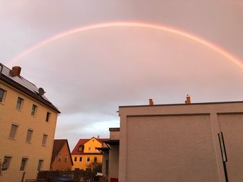 Low angle view of rainbow over buildings in city