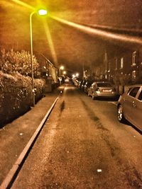 Road passing through illuminated city at night