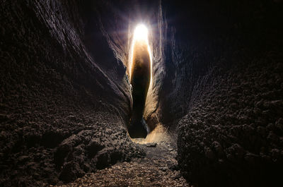 Low angle view of illuminated lighting equipment on rock at night