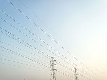 Low angle view of electricity pylon against clear sky