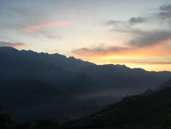 Scenic view of silhouette mountains against sky at sunset